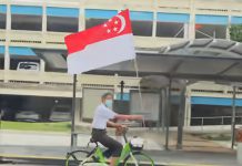 新加坡国庆月最燃画面!大叔骑共享单车带巨幅国旗巡游